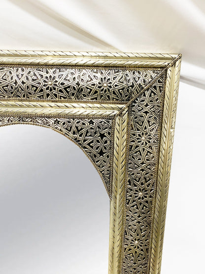 an ornate gold framed mirror on a white wall