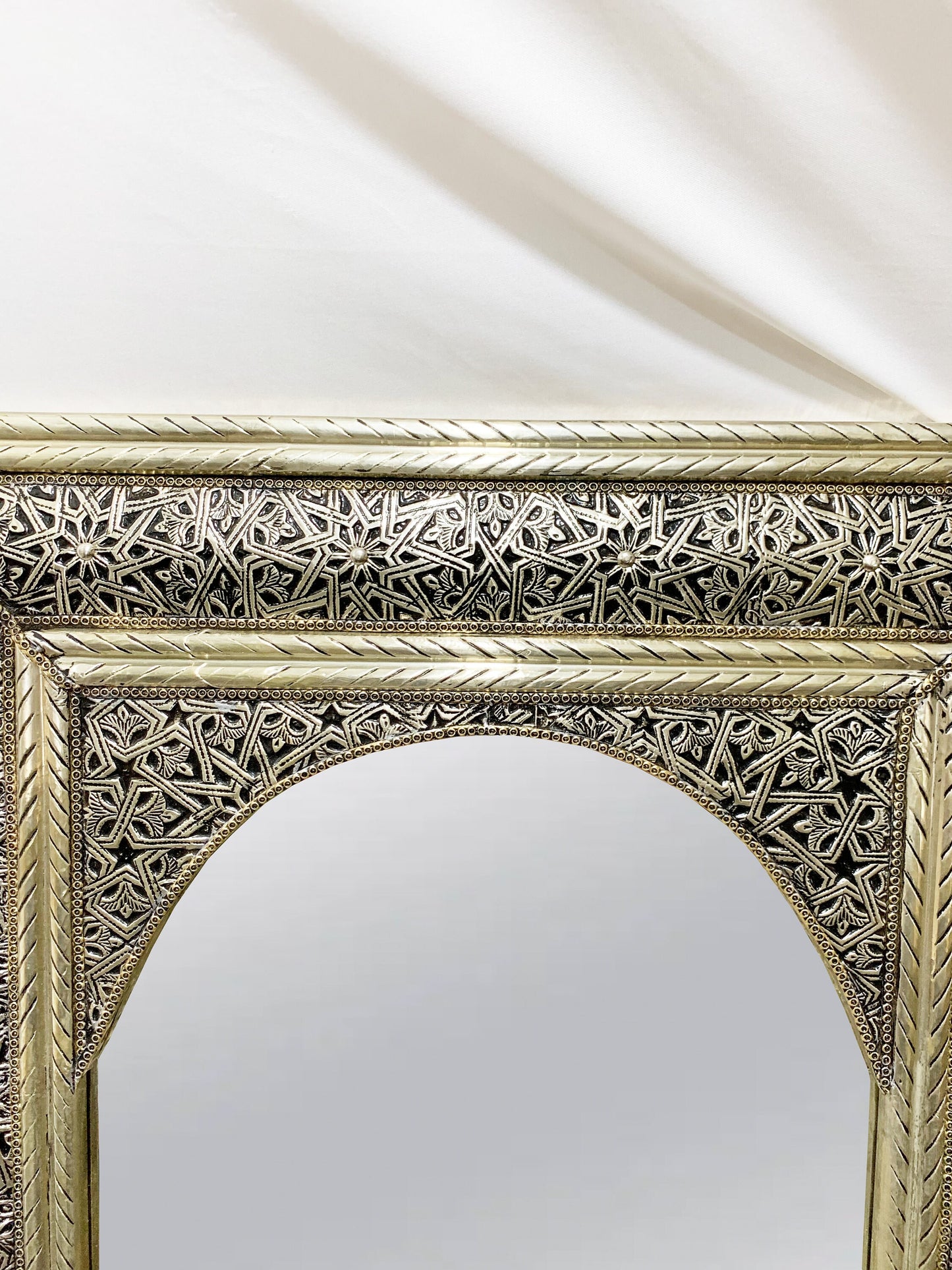 a gold framed mirror sitting on top of a table