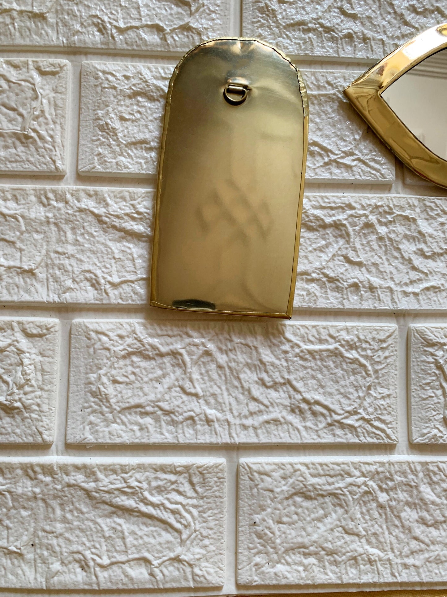 a white brick wall with a gold metal tag on it