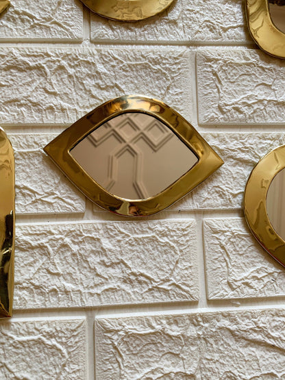 a white brick wall with gold mirrors on it