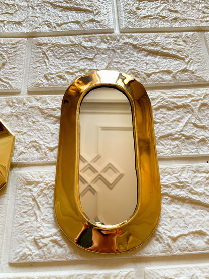 a gold mirror on a white brick wall