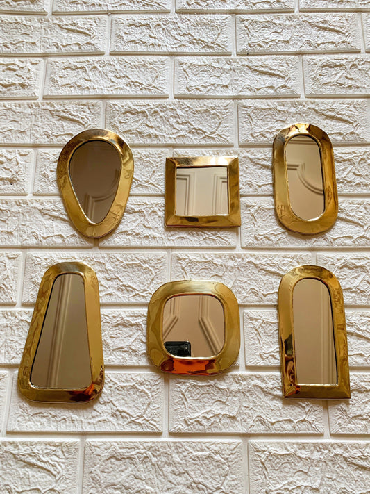 a white brick wall with gold mirrors on it