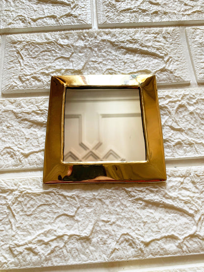 a mirror mounted to the side of a white brick wall