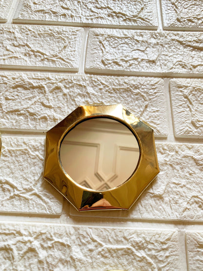 a mirror mounted to the side of a white brick wall