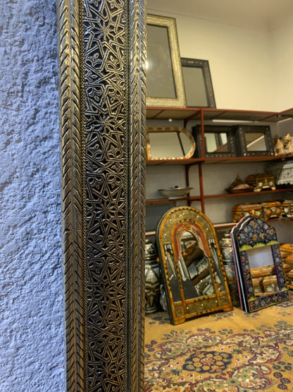 a large mirror sitting on top of a floor next to a wall