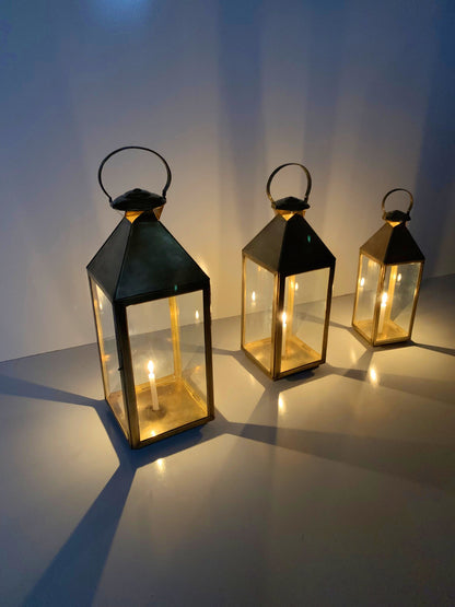 three lit up lanterns sitting on a table