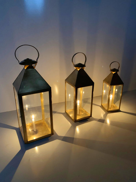 three lit up lanterns sitting on a table