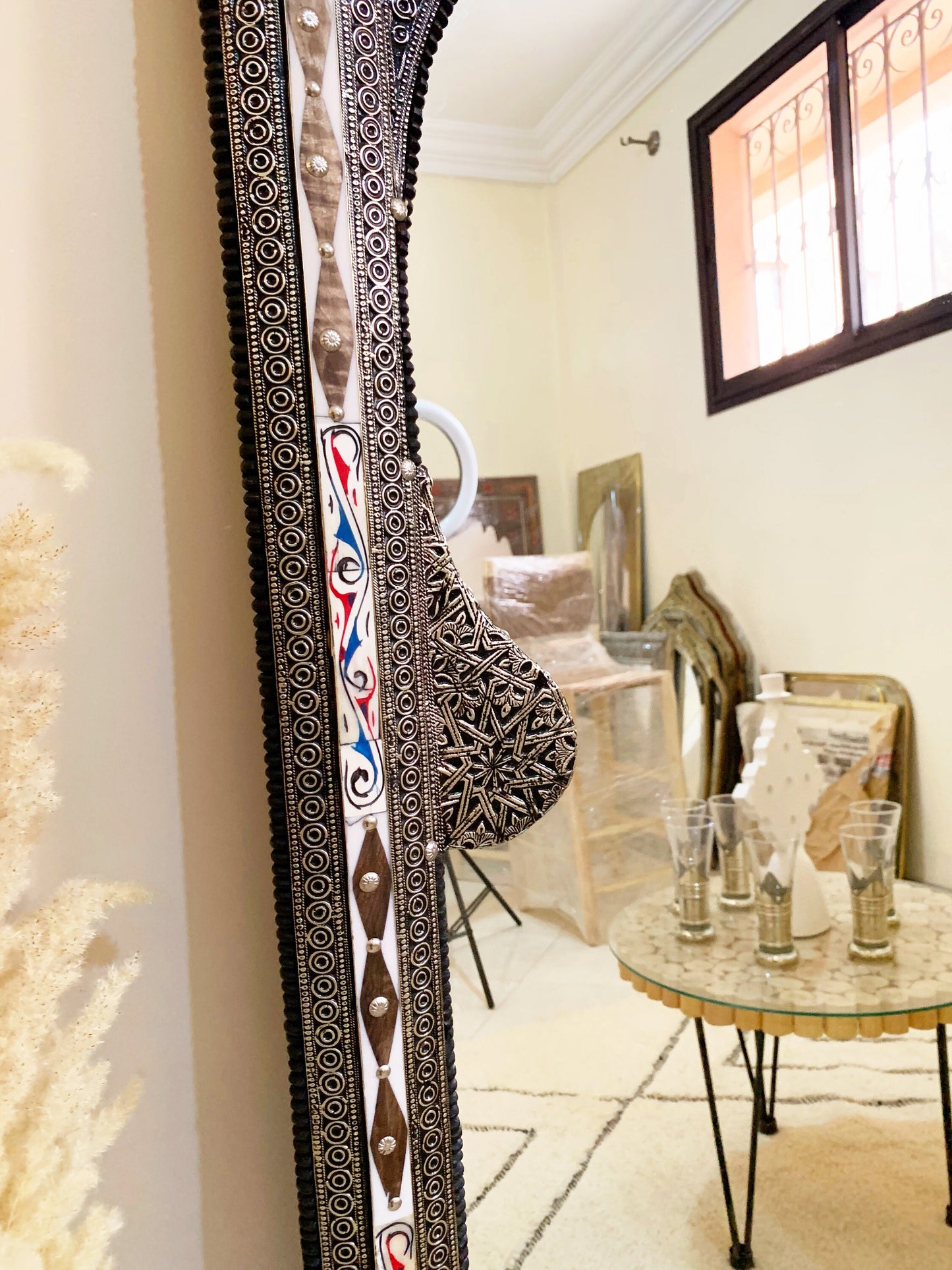 a mirror reflecting a room with a table and chairs