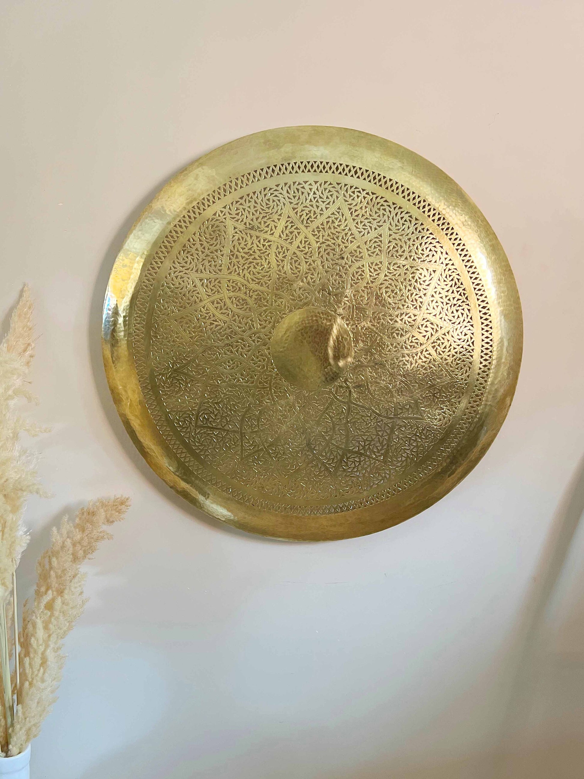 a gold plate hanging on a white wall