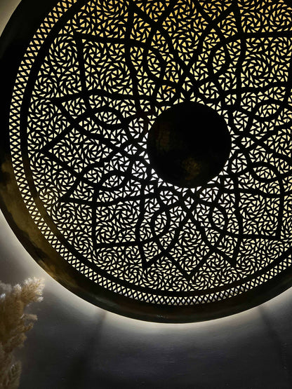 a circular light fixture with intricate designs on it