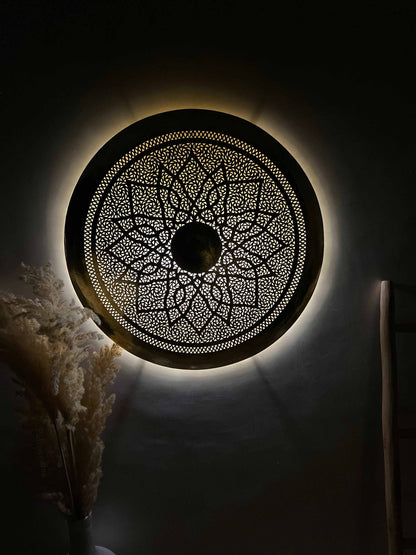 a decorative circular light fixture in a dark room