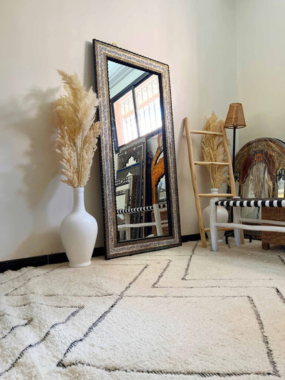 a full length mirror sitting on top of a white rug