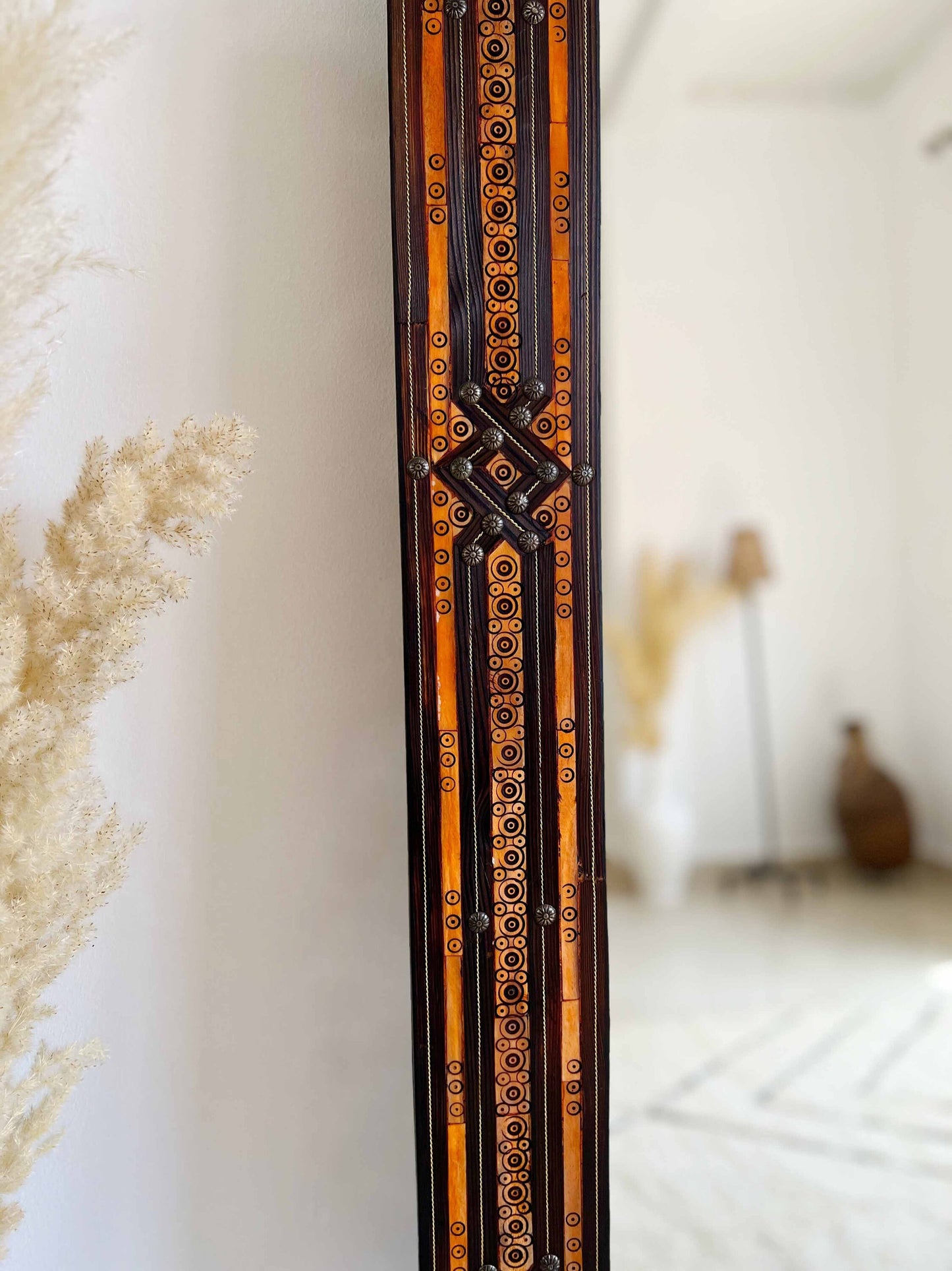 a tall wooden clock sitting on the side of a wall