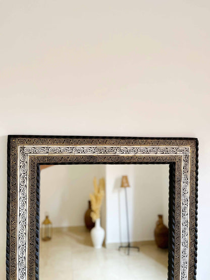 a mirror sitting on top of a wooden table