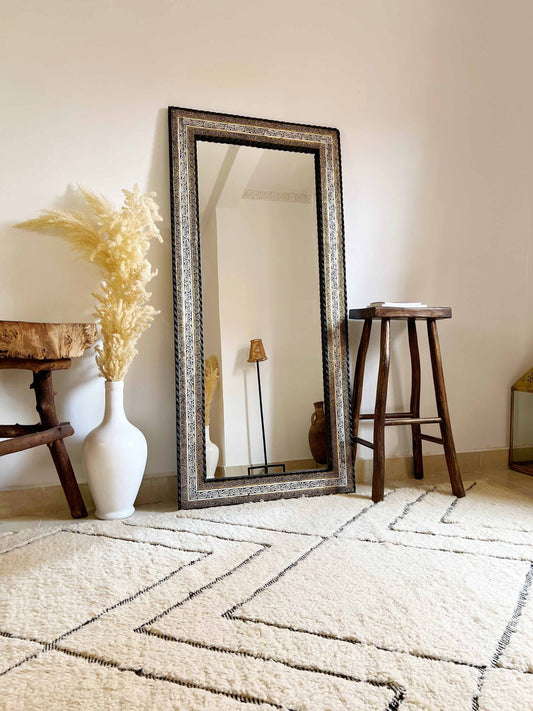 a full length mirror sitting on top of a white rug