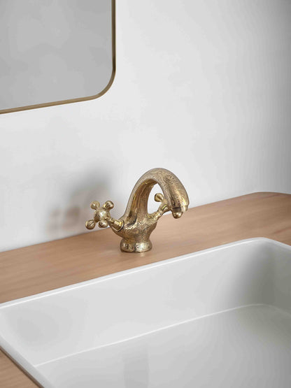 a bathroom sink with a gold faucet