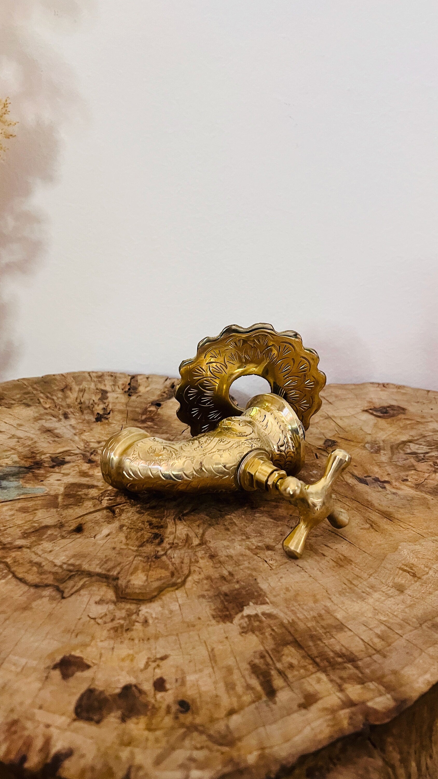 a golden faucet on a marble wall