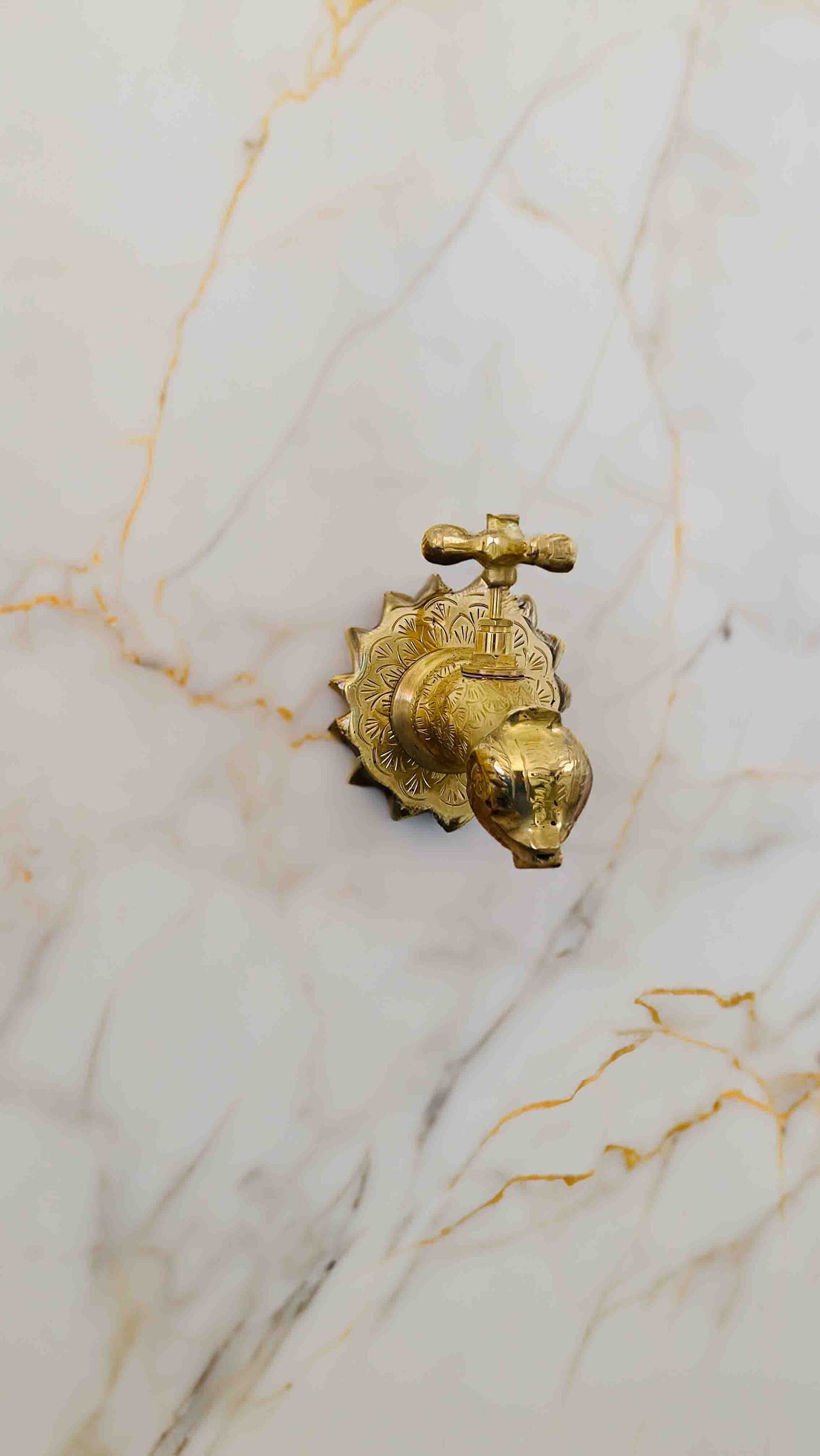 a golden faucet on a marble counter top