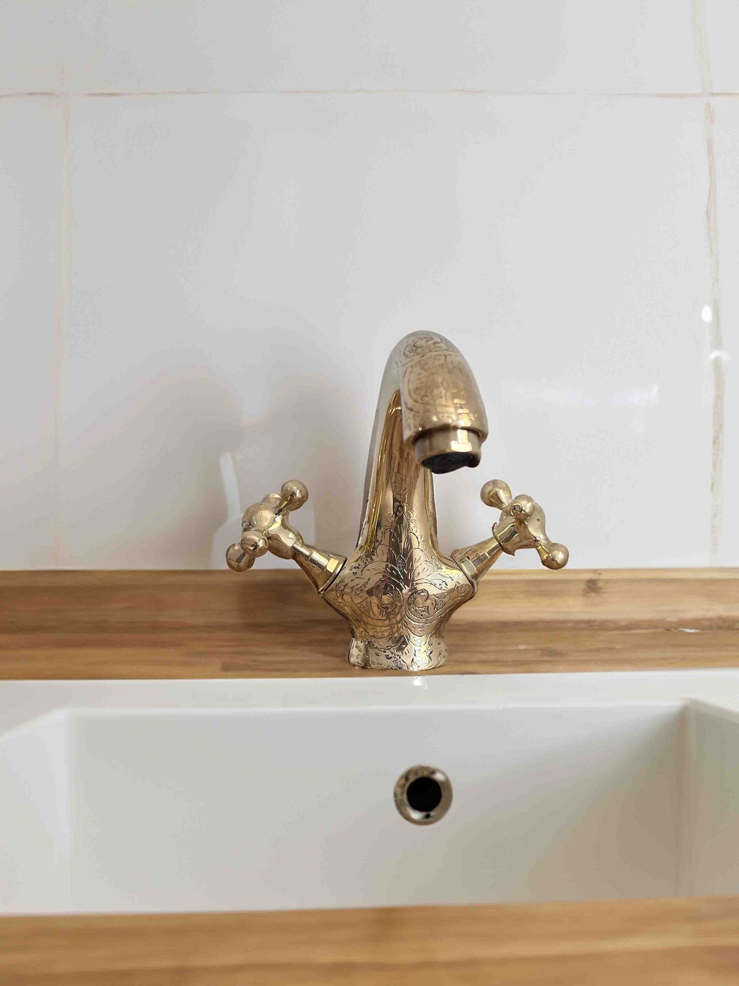 a gold faucet sitting on top of a white sink