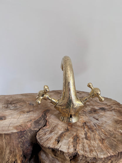 a brass faucet on a tree stump