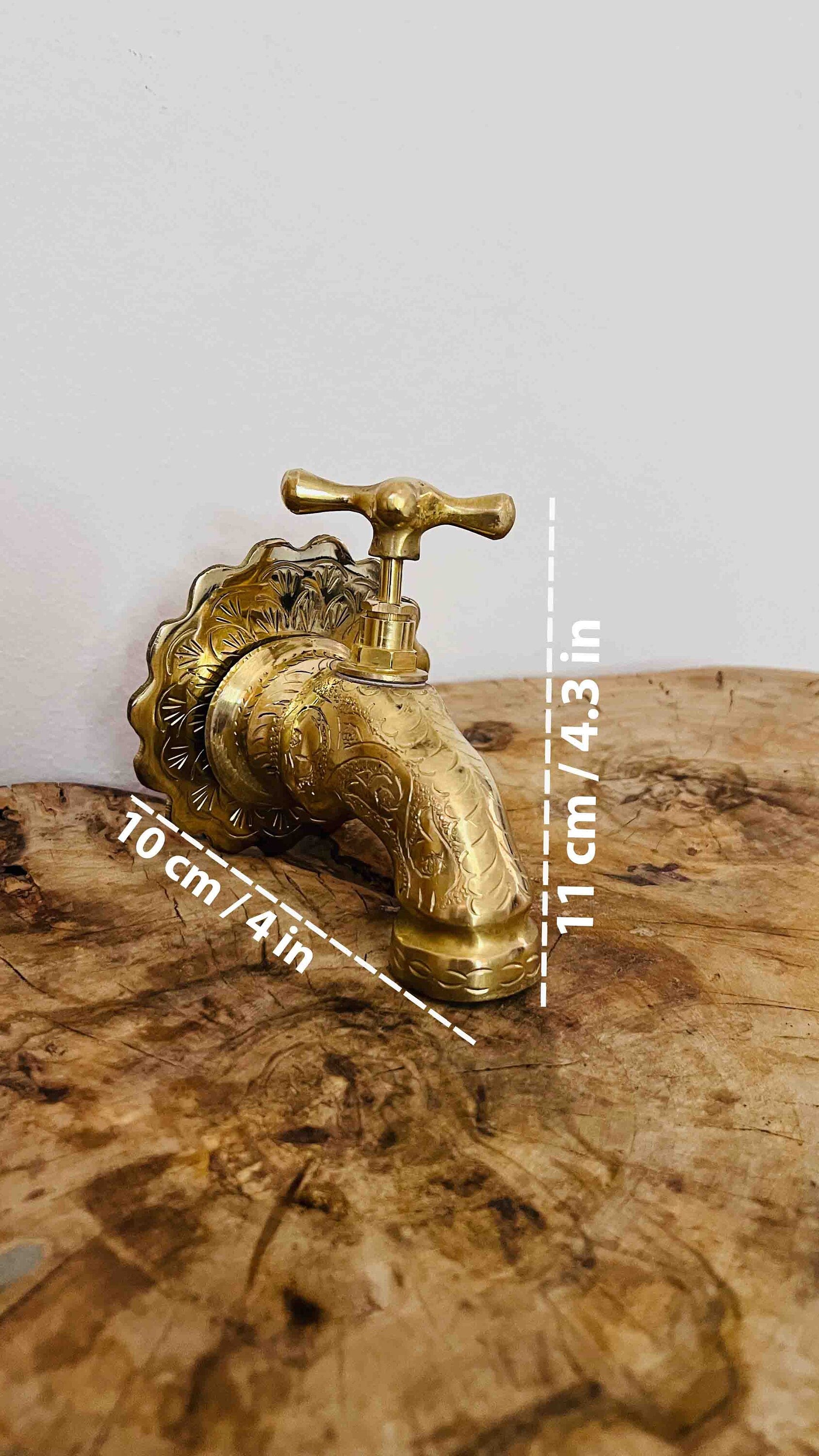 a golden faucet sitting on top of a wooden table