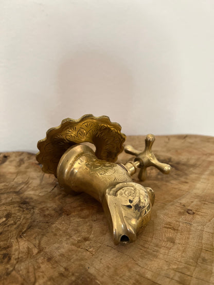 a golden faucet on a marble wall