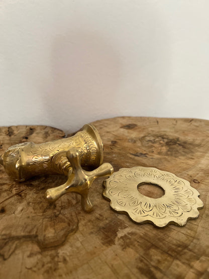 a golden faucet on a marble wall