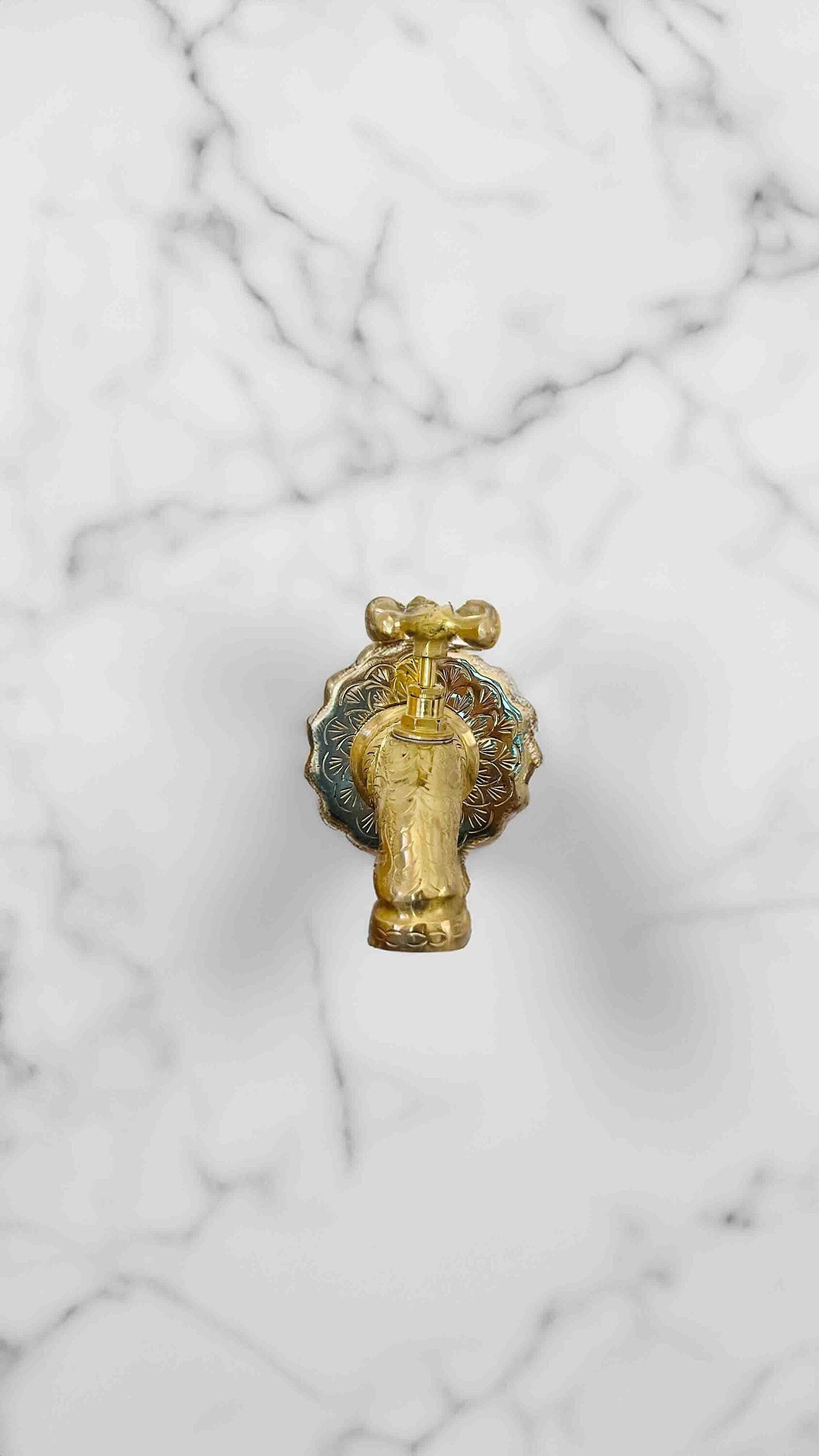 a golden faucet on a marble surface