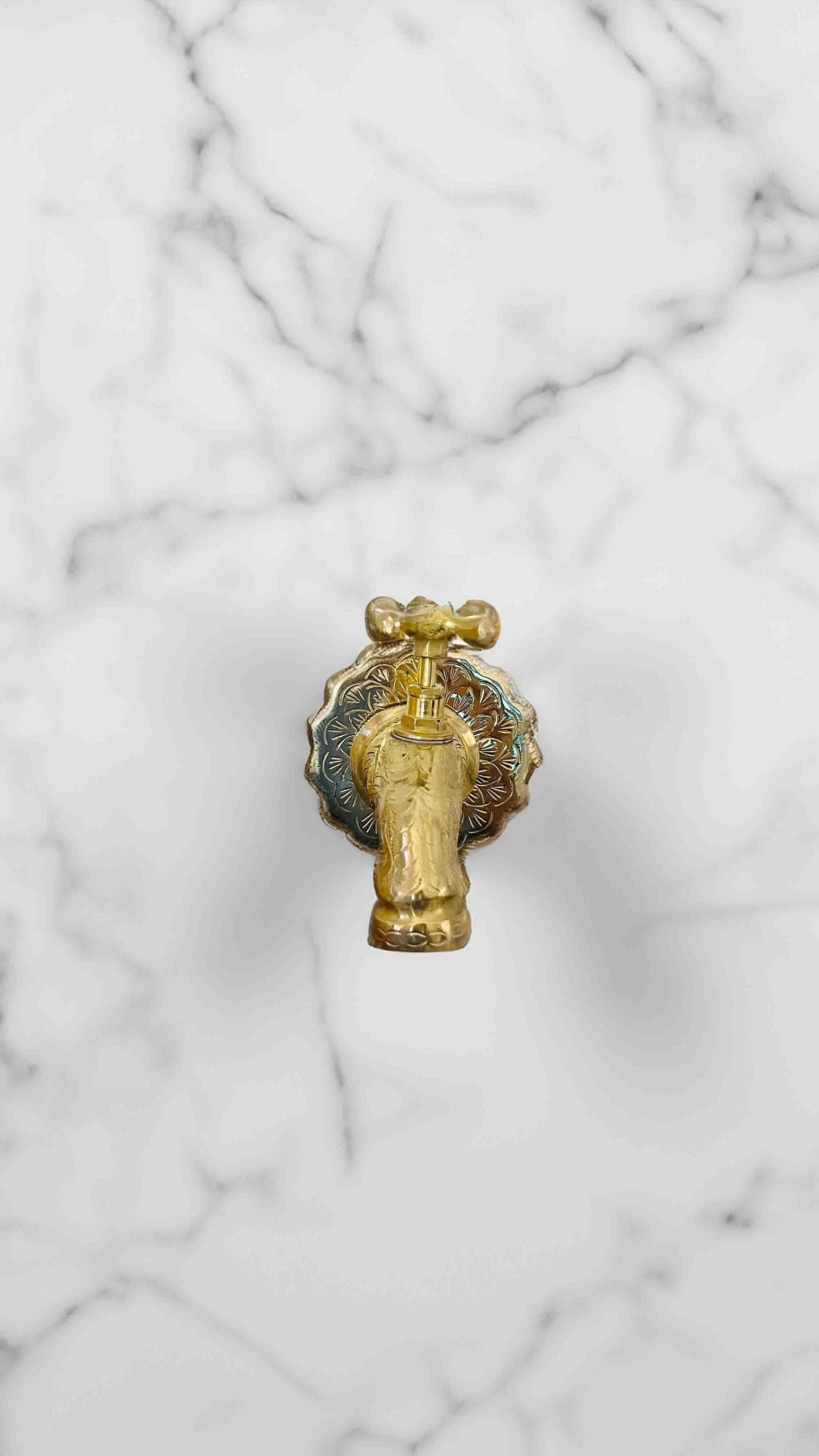 a golden faucet on a marble surface