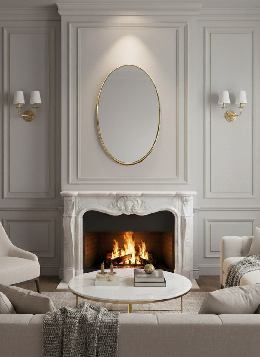 Oval brass mirror centered above marble fireplace in classic living room