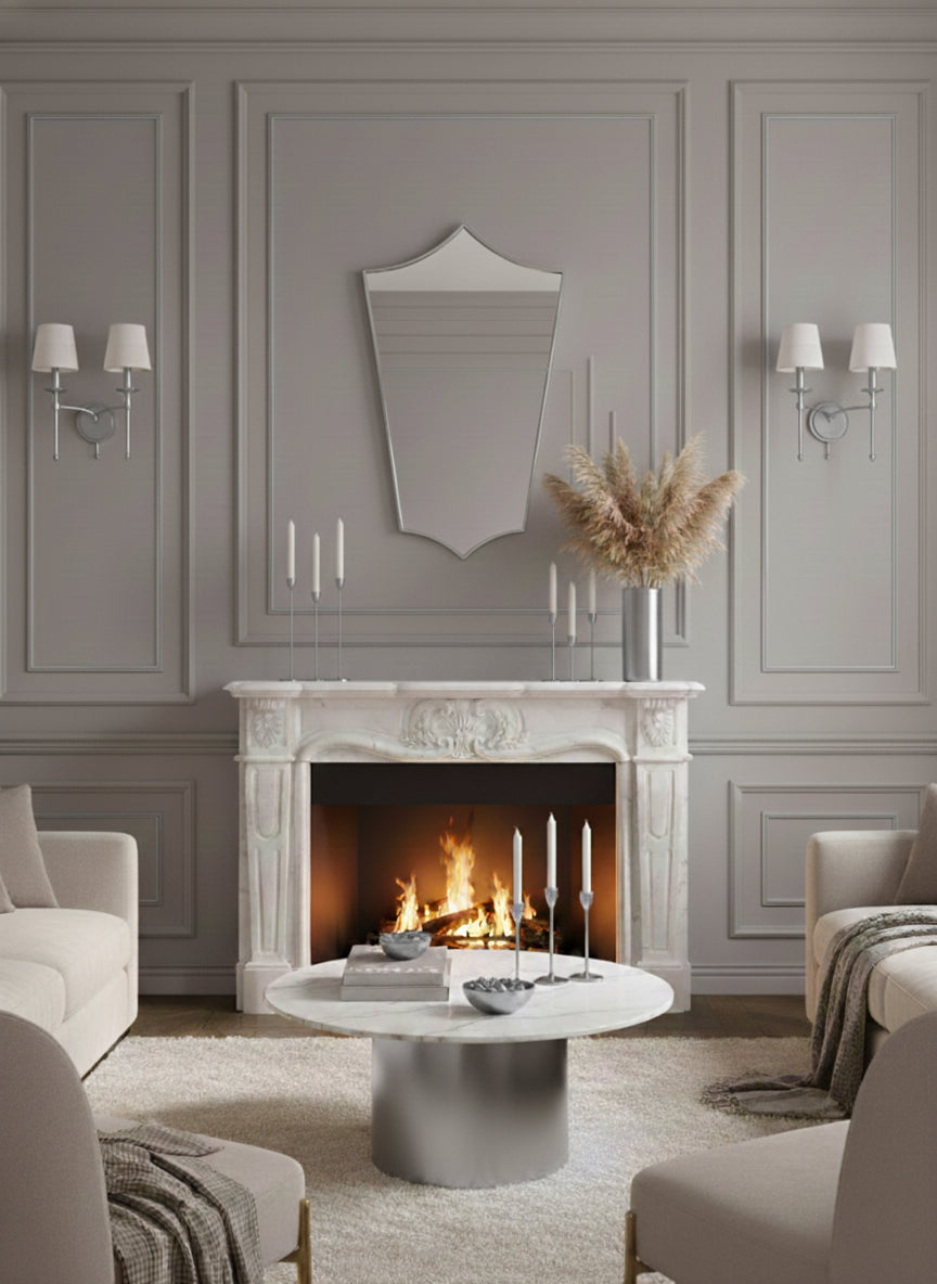Silver brass shield mirror above fireplace mantel in elegant living room.