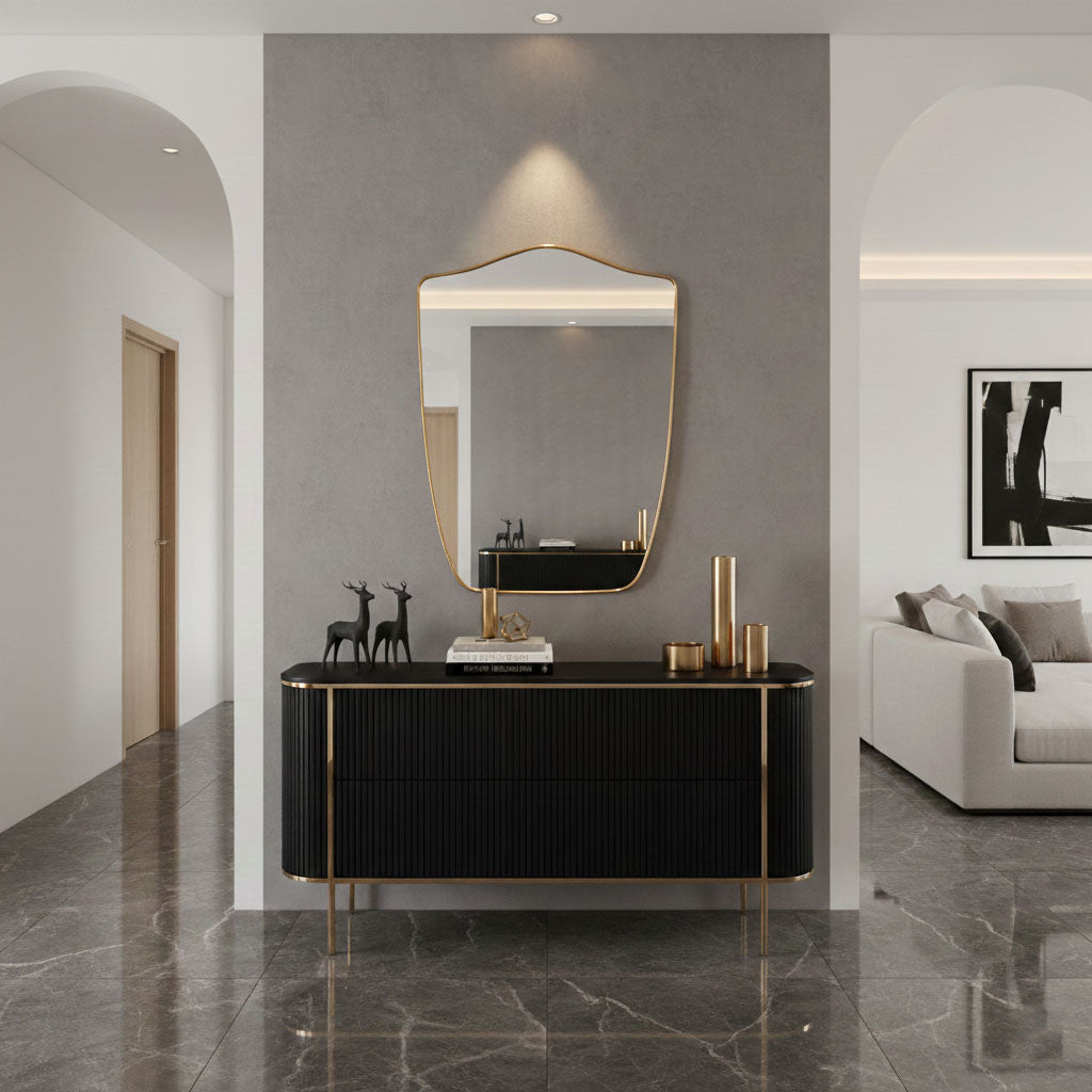 Shield wall mirror styled above black console in modern entryway