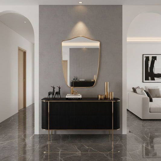 Shield wall mirror styled above black console in modern entryway