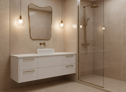 Irregular brass mirror above white floating vanity in modern beige bathroom.