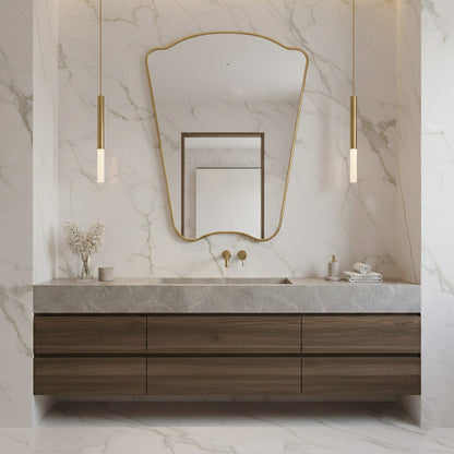 Asymmetrical Italian brass mirror on marble wall above modern wood vanity