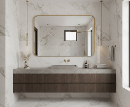 Large rectangular brass mirror in marble bathroom.