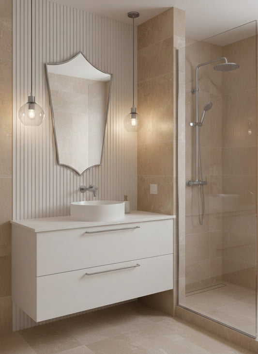 Silver brass shield mirror above white vanity in beige bathroom.