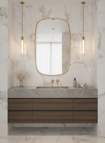 Oblong brass mirror with marble wall and floating vanity