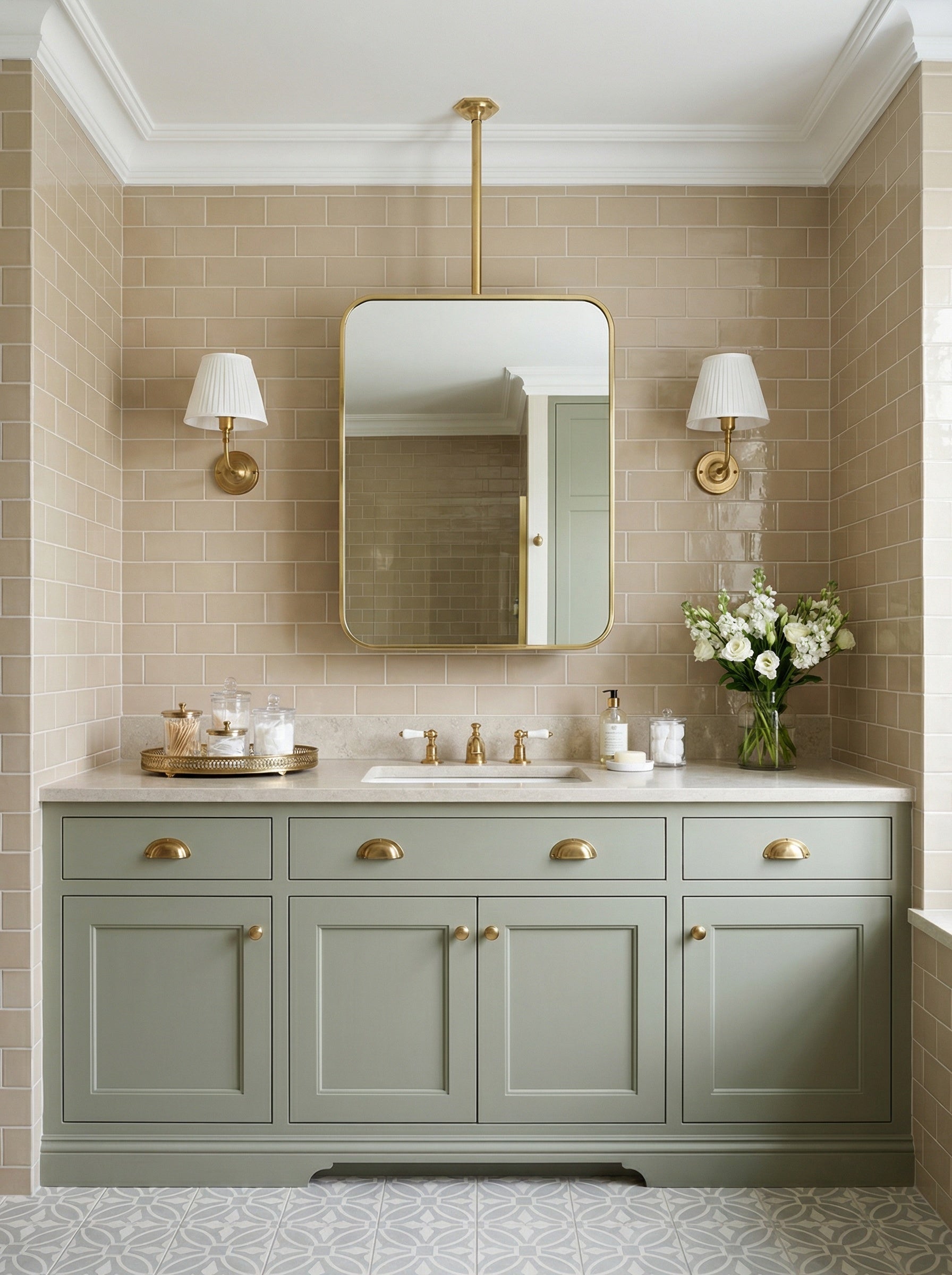 Modern rounded rectangle brass mirror above a sage green bathroom cabinet