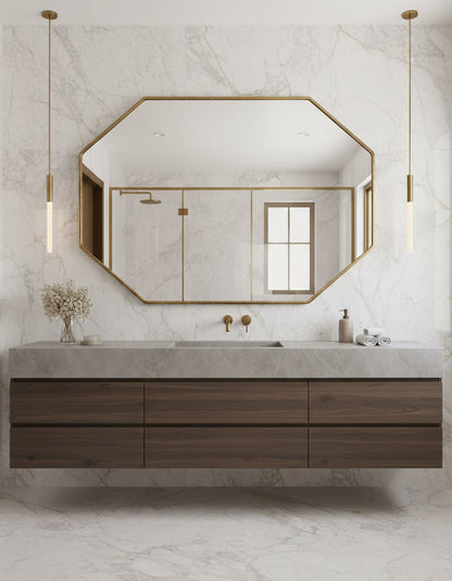 Large octagon brass mirror in marble bathroom.