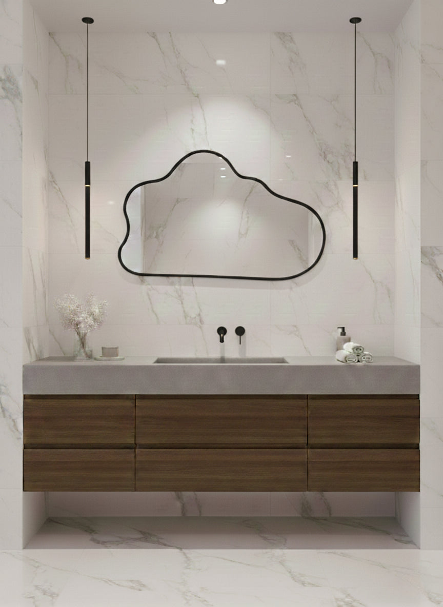 Black organic wall mirror above wood bathroom vanity.