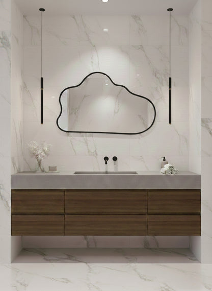 Black organic wall mirror above wood bathroom vanity.