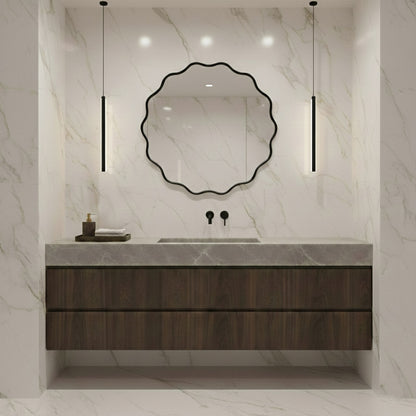Round wavy black mirror above dark wood vanity in marble bathroom.