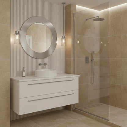 Round silver brass mirror over white floating vanity in beige bathroom.