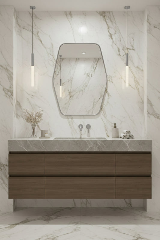 Hexagonal brass mirror over marble vanity with pendant lights.