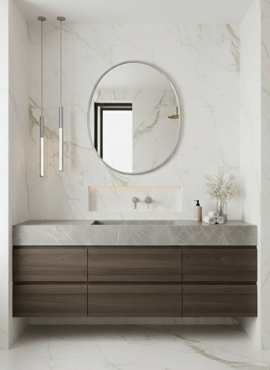 Round oval mirror above marble vanity in a luxury bathroom.