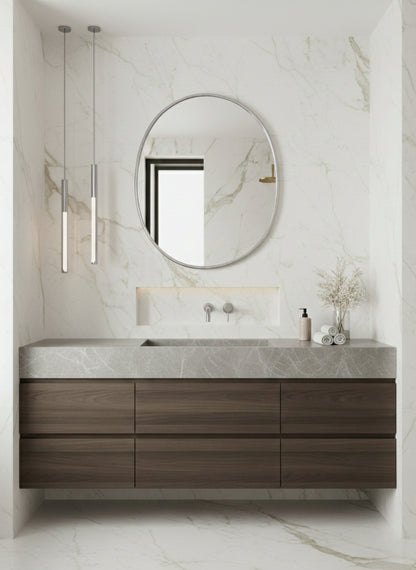 Round oval mirror above marble vanity in a luxury bathroom.
