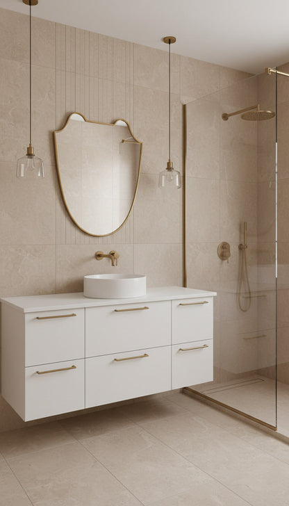 Shield brass mirror above modern white vanity and glass shower.
