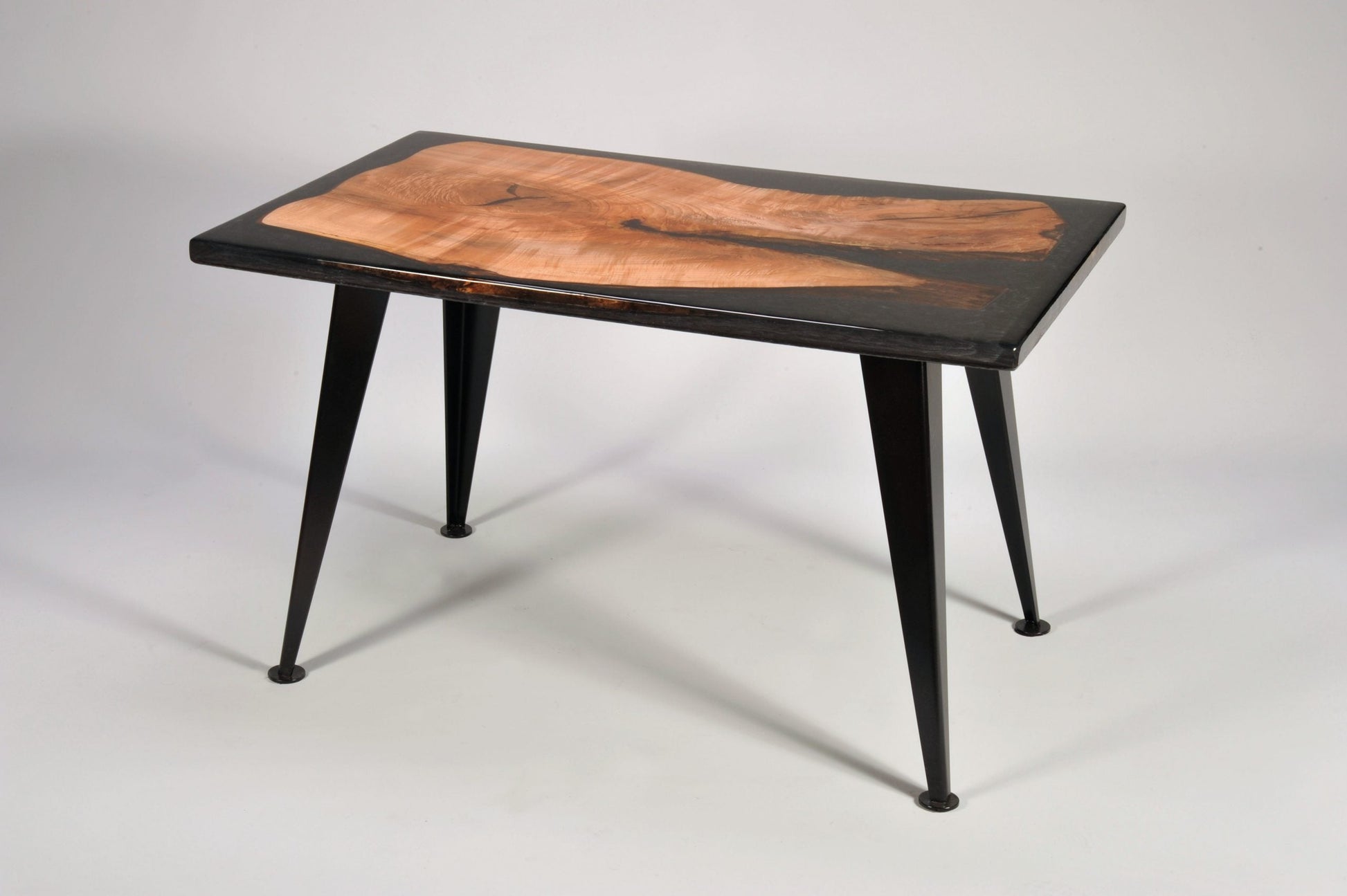 Wooden table with black metal legs on a white background