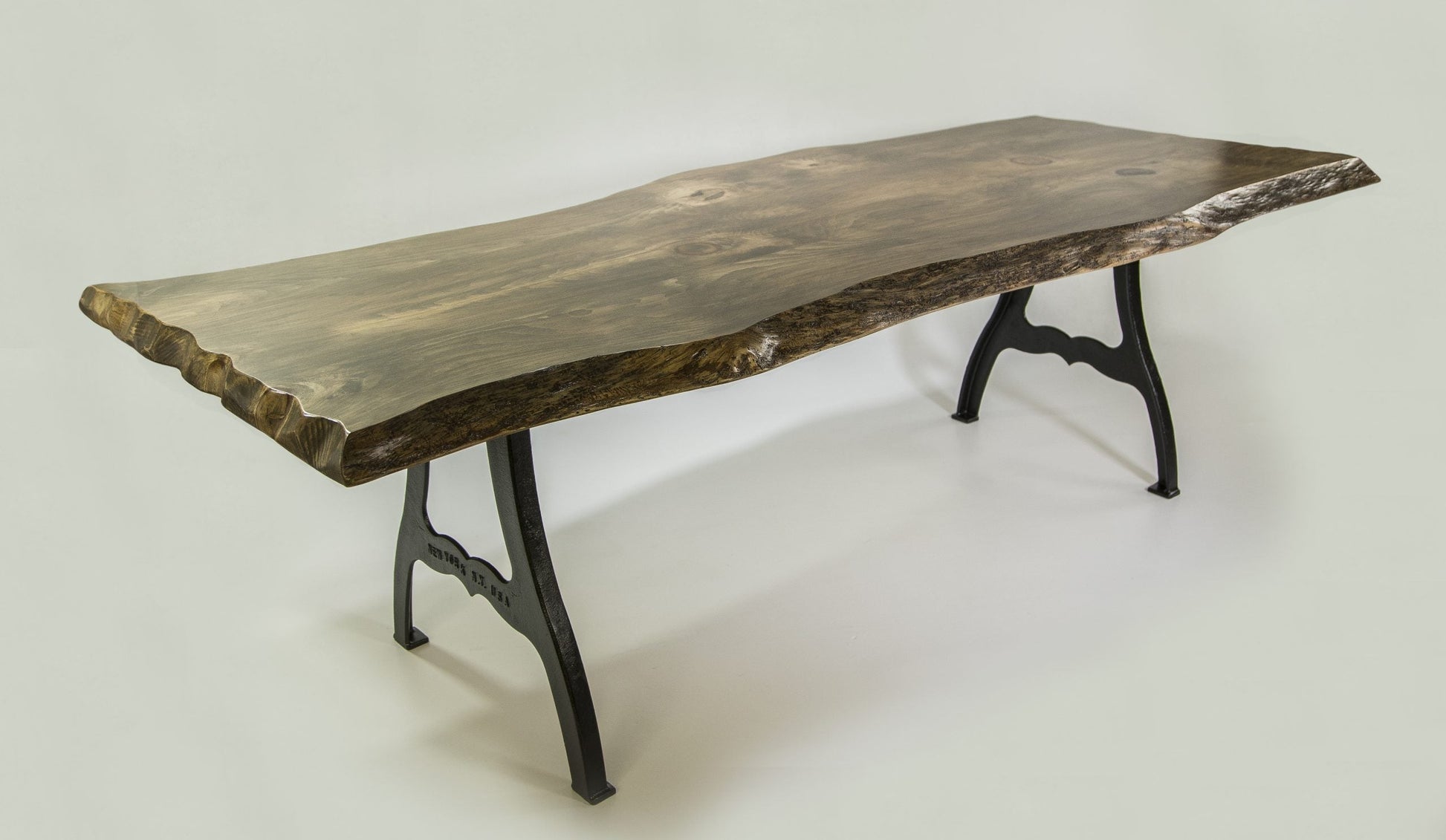 Wooden dining table with black metal legs on a white background